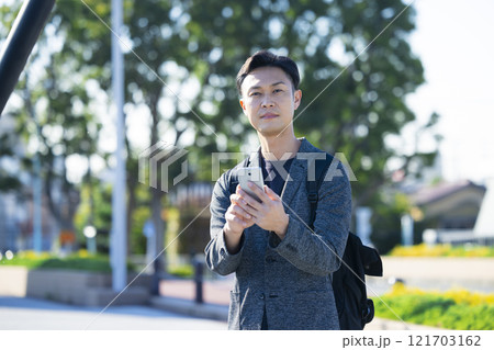 街中でスマホを持つ男性　 121703162