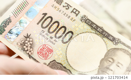男性が一万円札を持っている 121703414