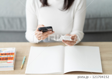 スマホでレシートを管理する女性　顔無し　 121704152