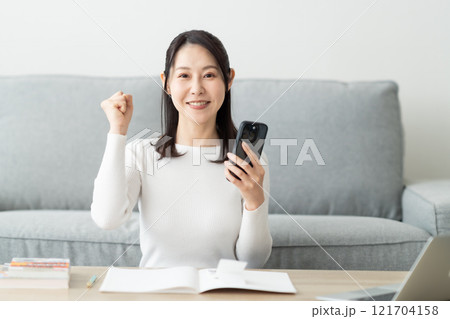 スマホで上手に家計簿をつけて満足なミドルの女性 121704158