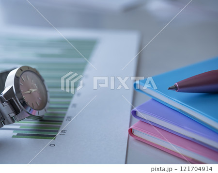 テーブルに置かれたグラフと手帳と腕時計 121704914