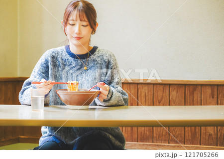 おいしいラーメンを食べてしあわせな若い女性 121705266