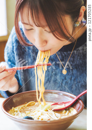 おいしいラーメンを食べてしあわせな若い女性 121705285