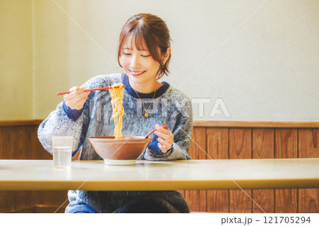 おいしいラーメンを食べてしあわせな若い女性 121705294