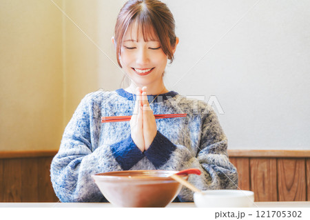 いただきますをしてラーメンを食べる若い女性 121705302