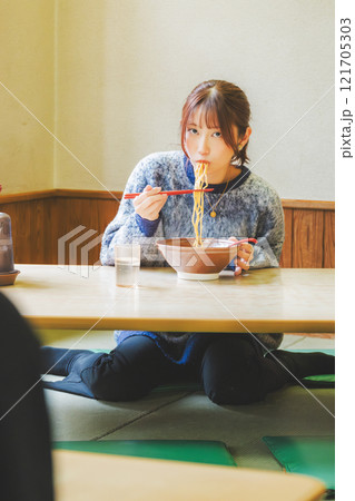 おいしいラーメンを食べてしあわせな若い女性 121705303