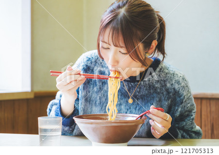 おいしいラーメンを食べてしあわせな若い女性 121705313