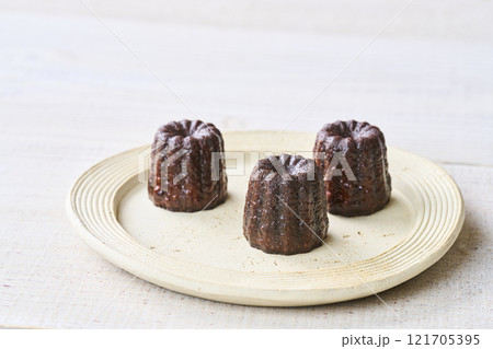 お皿に盛りつけられたカヌレ　洋菓子 121705395