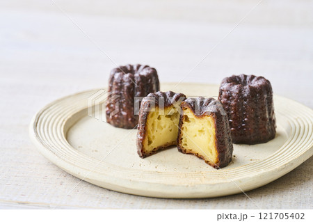 お皿に盛りつけられたカットされたカヌレ　洋菓子 121705402