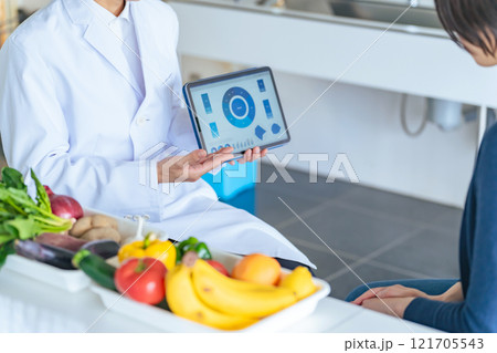 タブレット画面を見せて説明する白衣の男性 タブレット画面を見せて説明する白衣の男性 121705543