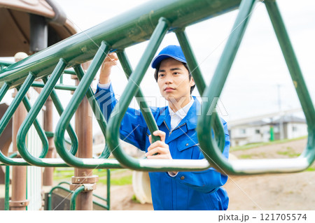 公園の遊具を安全点検する男性作業員 121705574