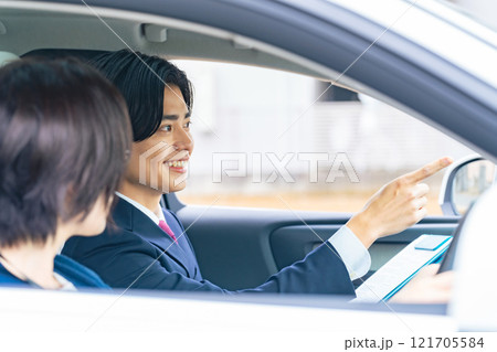女性に運転を指導する男性 自動車教習所 試乗車 カーディーラー 女性に運転を指導する男性 自動車教習所 試乗車 カーディーラー 121705584
