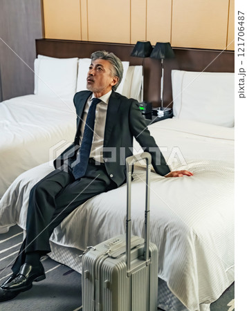 ベッドでリラックスするミドル男性ビジネスパーソン ベッドでリラックスするミドル男性ビジネスパーソン 121706487