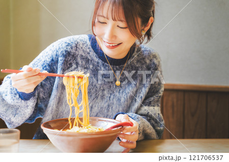 おいしいラーメンを食べてしあわせな若い女性 121706537