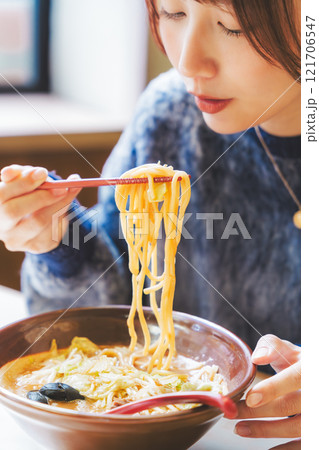 おいしいラーメンを食べてしあわせな若い女性 121706547