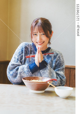 いただきますをしてラーメンを食べる若い女性 121706555