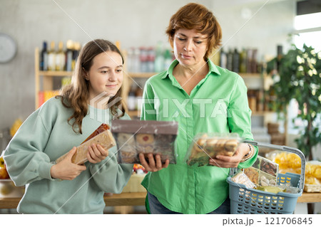 Woman with a child chooses sweets Woman with a child chooses sweets 121706845