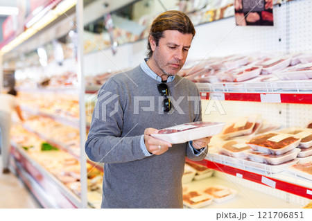 Man looking for packaged mutton in grocery store 121706851