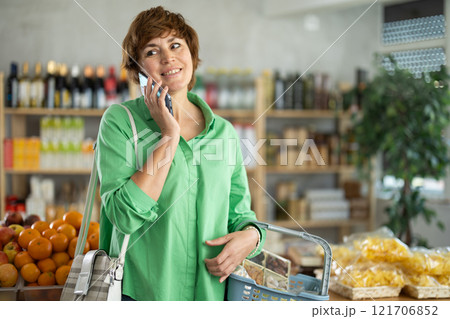 Woman with phone in hands walks around store 121706852