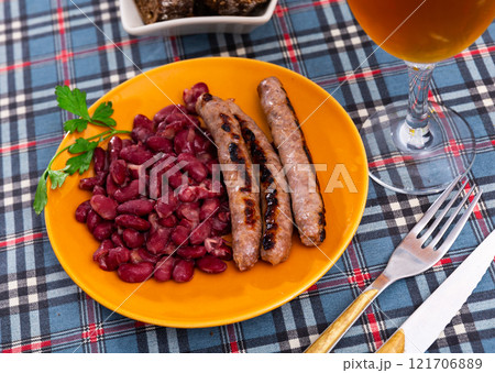 Fried red beans and sausage served on plate and decorated with greenery, traditional dish of Catalonia Fried red beans and sausage served on plate and decorated with greenery, traditional dish of Catalonia 121706889