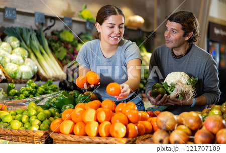 Husband and wife choose fresh fruits and vegetables together in grocery supermarket 121707109