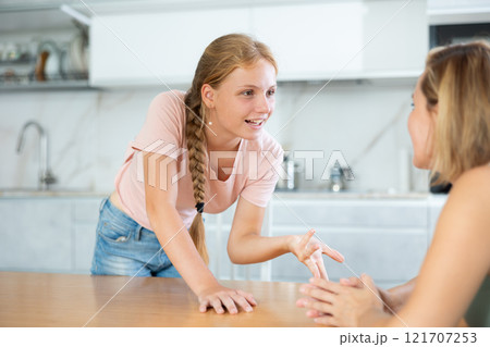 Teenage daughter enthusiastically tells unrecognizable mother about planned vacation with friends 121707253