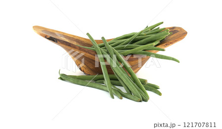 Fresh green beans overflowing a wooden bowl on white background 121707811