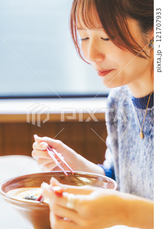 おいしいラーメンを食べてしあわせな若い女性 121707933