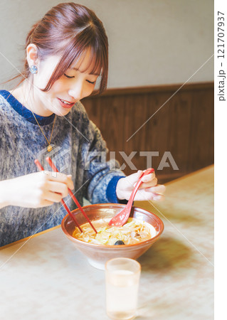 おいしいラーメンを食べてしあわせな若い女性 121707937