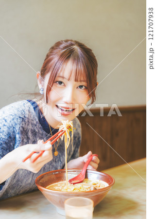 おいしいラーメンを食べてしあわせな若い女性 121707938