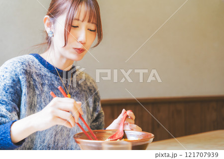 おいしいラーメンを食べてしあわせな若い女性 121707939