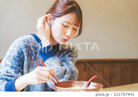 おいしいラーメンを食べてしあわせな若い女性 121707941