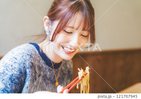 おいしいラーメンを食べてしあわせな若い女性 121707945