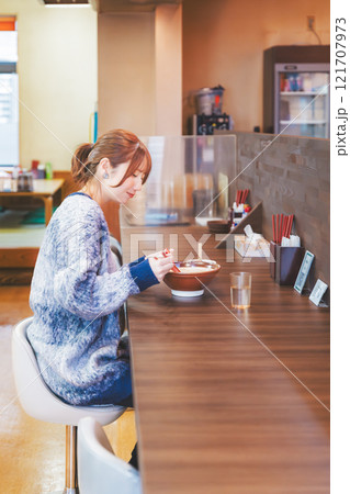 おいしいラーメンを食べてしあわせな若い女性 121707973