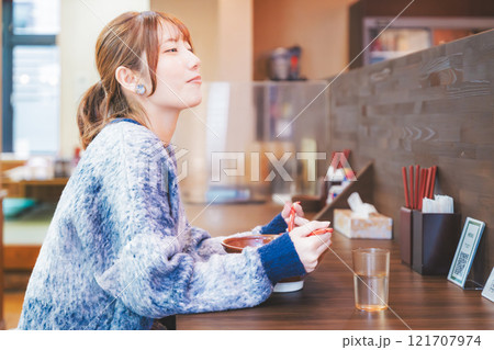 おいしいラーメンを食べてしあわせな若い女性 121707974