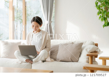 リビングでパソコンを使う女性 121709527