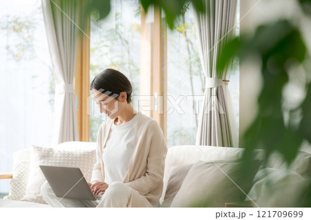 ソファでパソコン作業をする女性 121709699