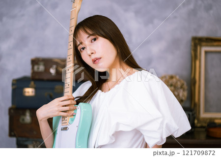 エレキギターを持つロングヘアの若い女性 121709872