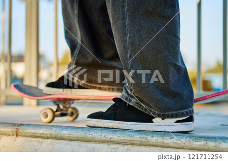 Skateboarder riding on pink skateboard at skatepark 121711254