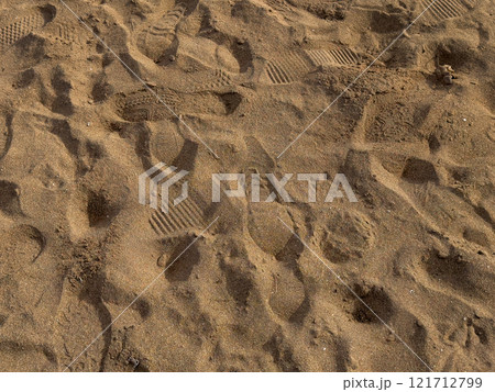 Footprints and patterns in sandy terrain 121712799