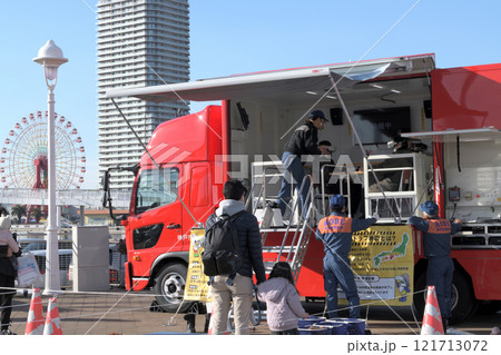 地震体験車「ゆれるん」　揺れを体験する家族　　 121713072