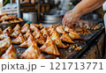 Cook carefully folding samosas with a pillow 121713771