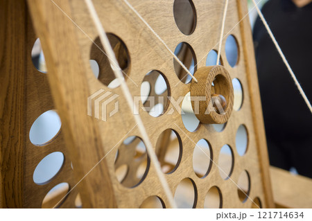 Intricate Wooden Mechanism Featuring Circular Holes and a Functional Pulley System 121714634