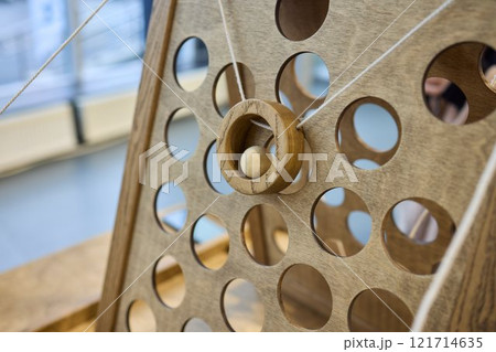 Intricate Wooden Mechanism Featuring Circular Holes and a Functional Pulley System 121714635