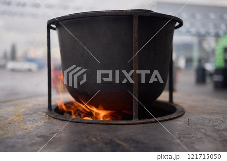 The Glow of Embers and Flames in a Steel Cooking Pot Outdoors Under the Starry Sky The Glow of Embers and Flames in a Steel Cooking Pot Outdoors Under the Starry Sky 121715050