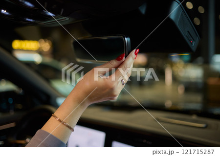 Discover a modern car interior with a stylish hand adjusting mirror for added functionality 121715287