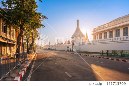 Na Phra Lan Road in front of The Bangkok Grand Palace featuring white walls and traditional architecture under a sunrise sky. 121715709
