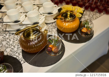 The elegant teapots, cups, and tea are beautifully arranged on a sophisticated table The elegant teapots, cups, and tea are beautifully arranged on a sophisticated table 121715916