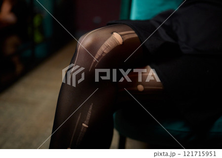 An Elegant Fashion Stock Image Featuring Stylish Fishnet Tights and a Model Posing in a Unique Way 121715951