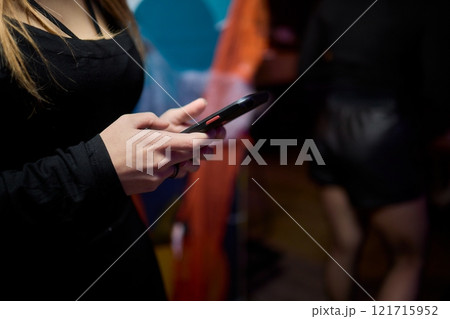 Woman in stylish dress with chic manicure using smartphone in closeup shot Woman in stylish dress with chic manicure using smartphone in closeup shot 121715952